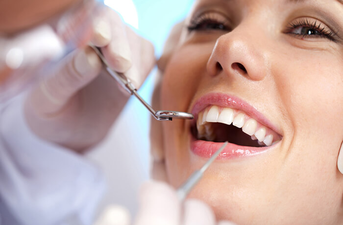 Dentista examina boca de mulher